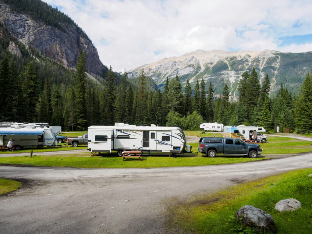 A beautiful campsite featuring RVs amidst lush forests and towering mountains for a peaceful getaway.